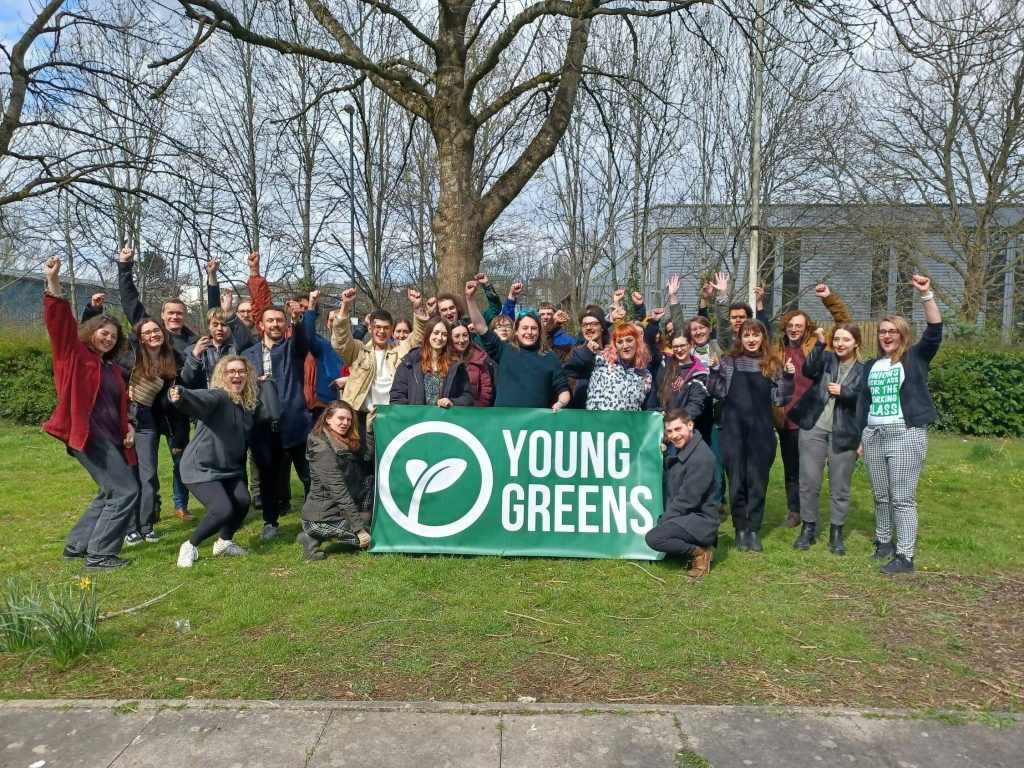 30 Under 30 2022 30 Under 30 Graduates from 2022 holding the Young Greens banner with their fists raised