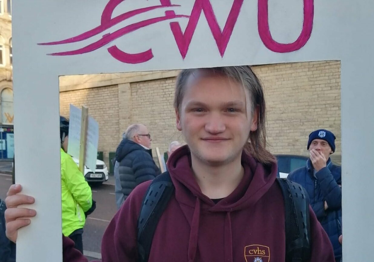 Finn_23 Finn smiling towards camera holding a CWU sign